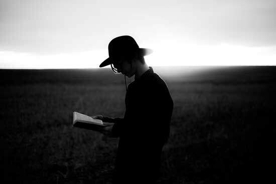 A farmer studying the Bible in a field just as William Miller studied Bible prophecy