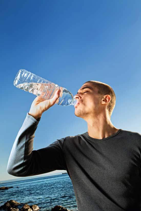 Man drinking water as we learn that drinking enough water can greatly reduce risk of heart disease and stroke.