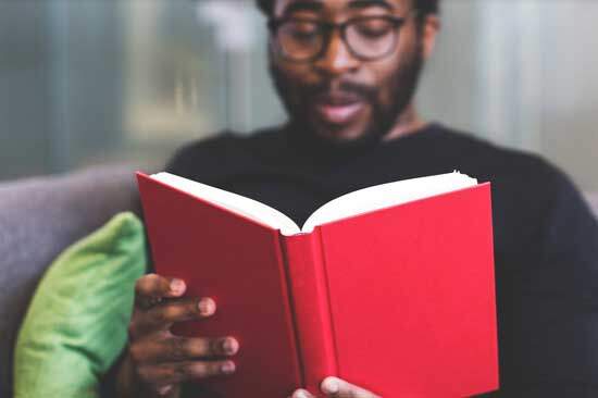 A man reading one of Ellen White's books with a red cover to test it for himself