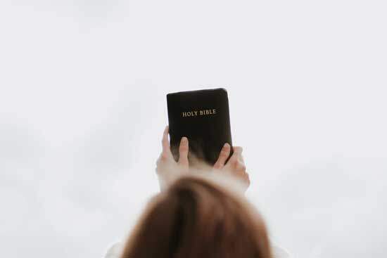 A girl holding a Bible, the book that came to us through the gift of prophecy