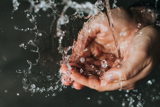 Water splashing on hands as we discuss the importance of water, its physical benefits and spiritual applications.