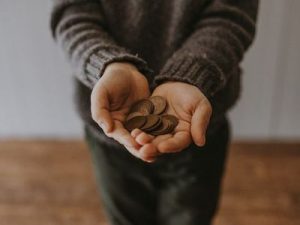 Adventist holding out tithe and offering money.