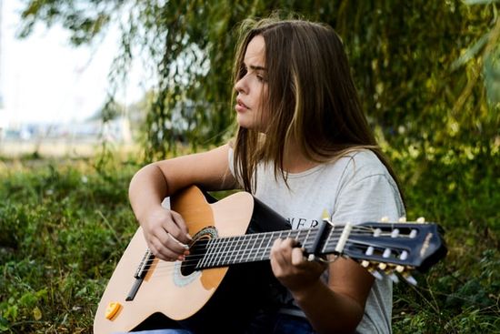 A girl playing guitar outdoors on the Sabbath day