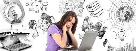  A woman is sitting in front of her laptop with an overwhelmed expression