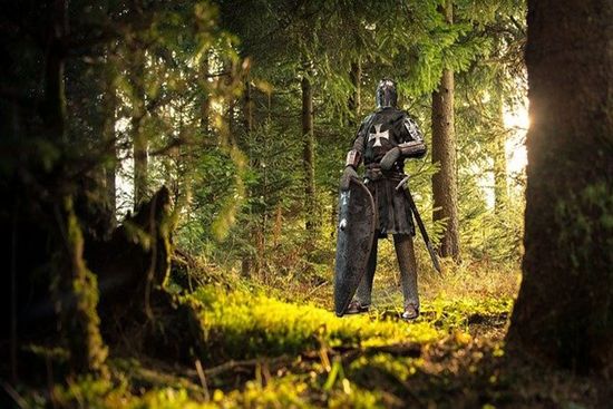Soldier with full battle armor on him standing in woods as we discuss the Armor of God as described in the book of Ephesians.