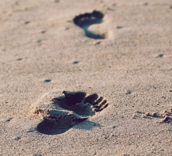 Footsteps in the sand, representing the journey of the Christian life