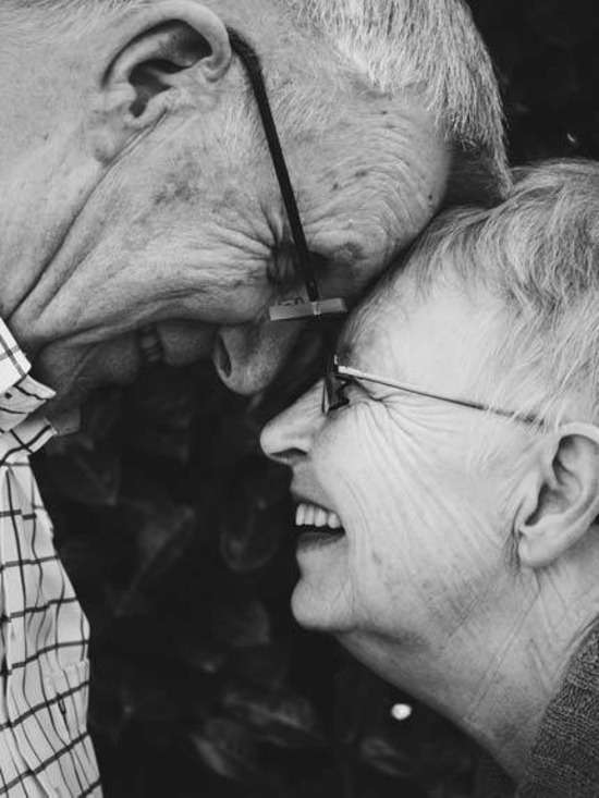 An Old couple laughing with their foreheads touching each other, filled with joy and peace - AAAF