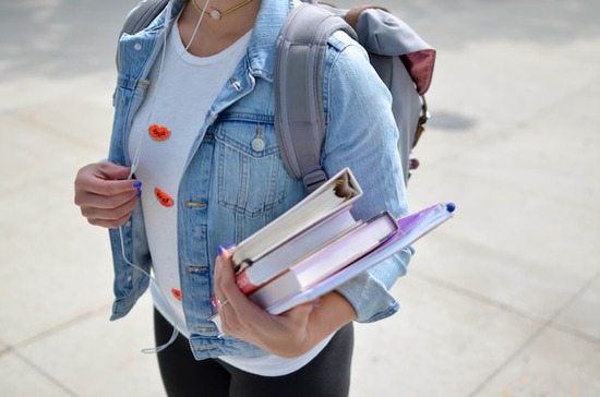 A young woman carrying books for canvassing