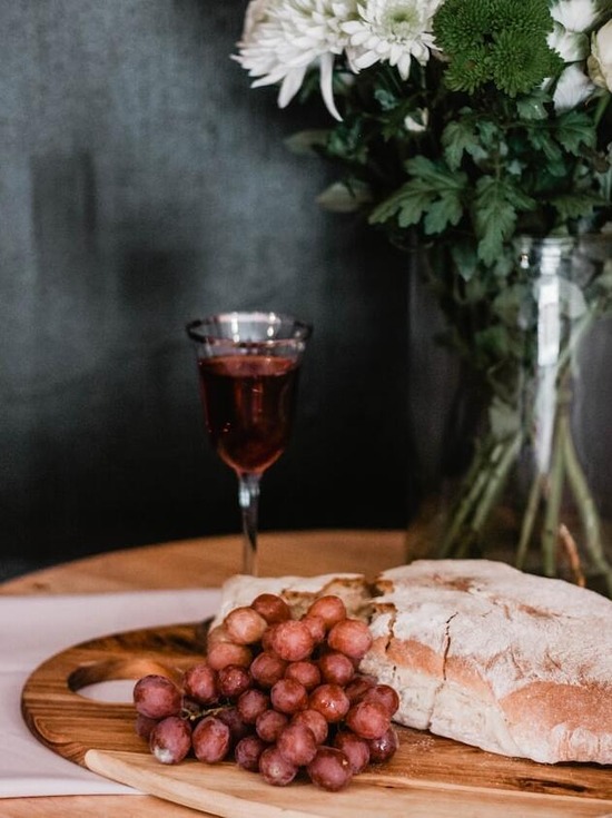 A table with bread, grapes, and grape juice, foods that are symbols in the Lord's Supper
