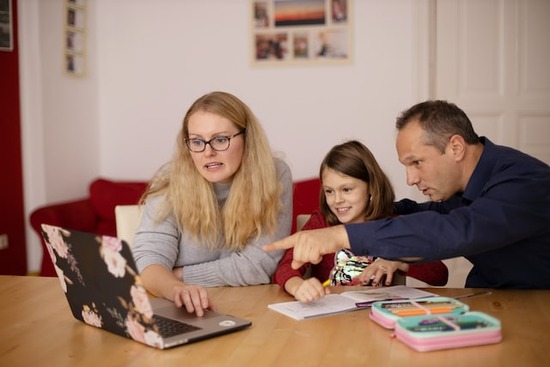 Parents helping their daughter with homework