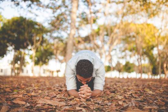 A man on his knees in worship of God