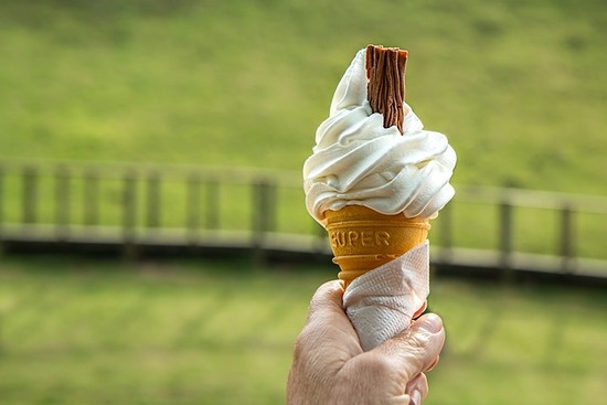 A hand holding an ice cream cone, a food that requires self-control