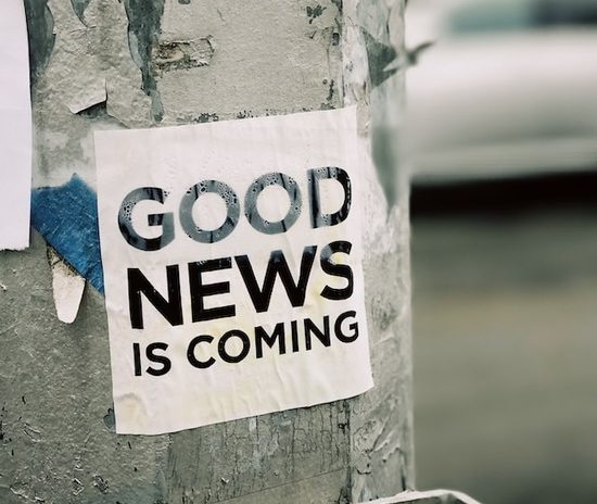 A sign on a post that says, Good news is coming