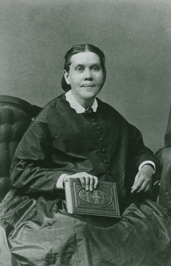 Ellen White sitting and holding a book