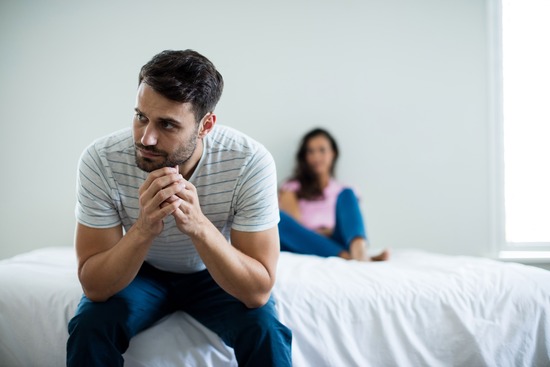A man facing away from his wife in frustration over an argument