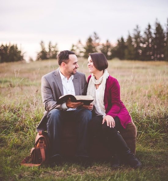 A married couple reading the Bible together as they make Christ the center of their marriage