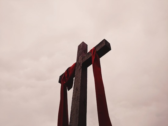 A cross with a red cloth draped over it to represent Jesus' death on Good Friday