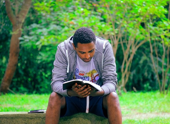 A man reads his Bible outdoors to get the spiritual benefits of fresh air