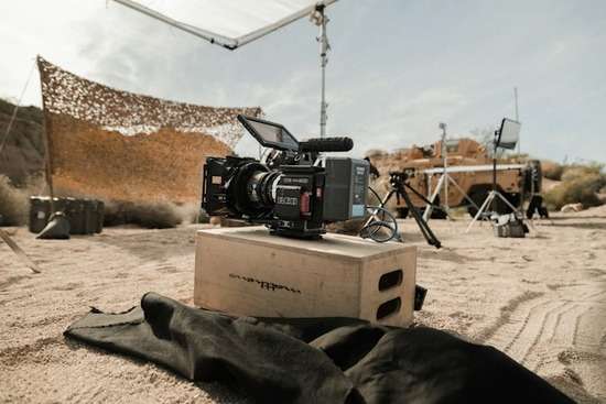 A film camera on a set for a Bible scene in the desert