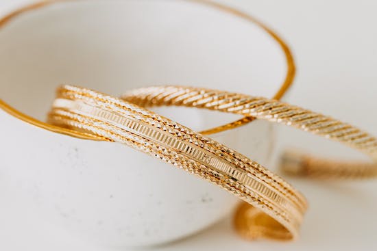  Gold bracelets in a white cup