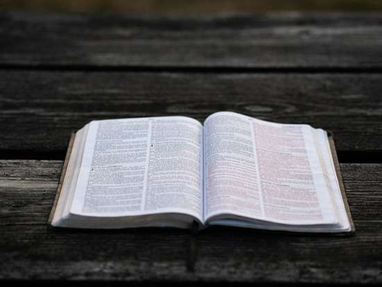 A Bible open on a wooden table