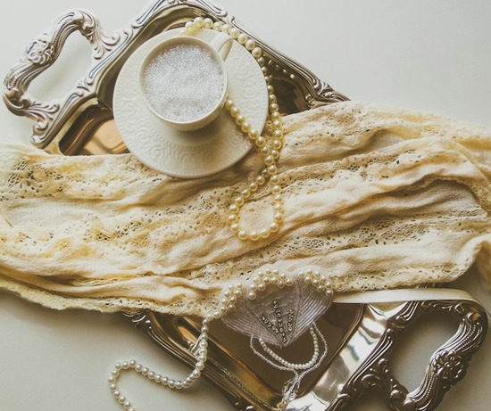 Vintage jewelry like pearl necklaces on a silver platter 