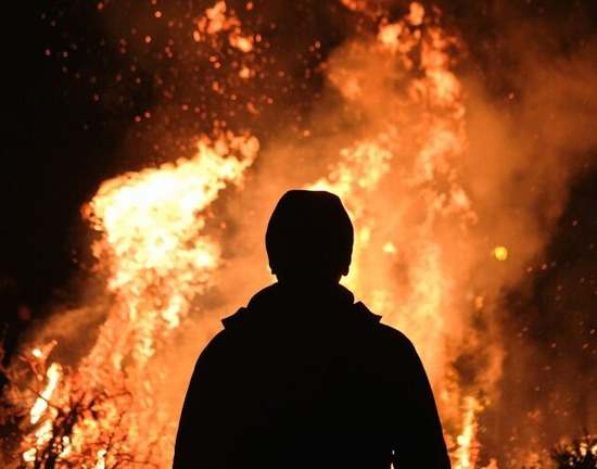 A man standing in front of a fire, similar to the burning bush Moses saw