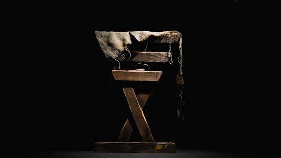 A wooden manger, like the one that was believed to hold Jesus, contains old, fraying blankets.
