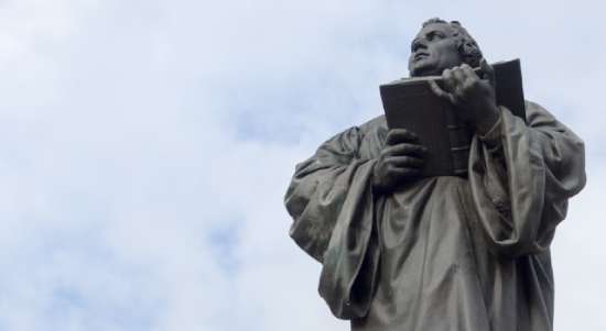 A statue of Martin Luther reading the Bible