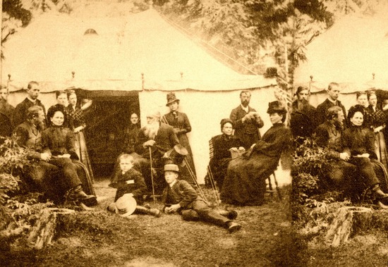 A black and white photo of people gathered outside a tent for a meeting.