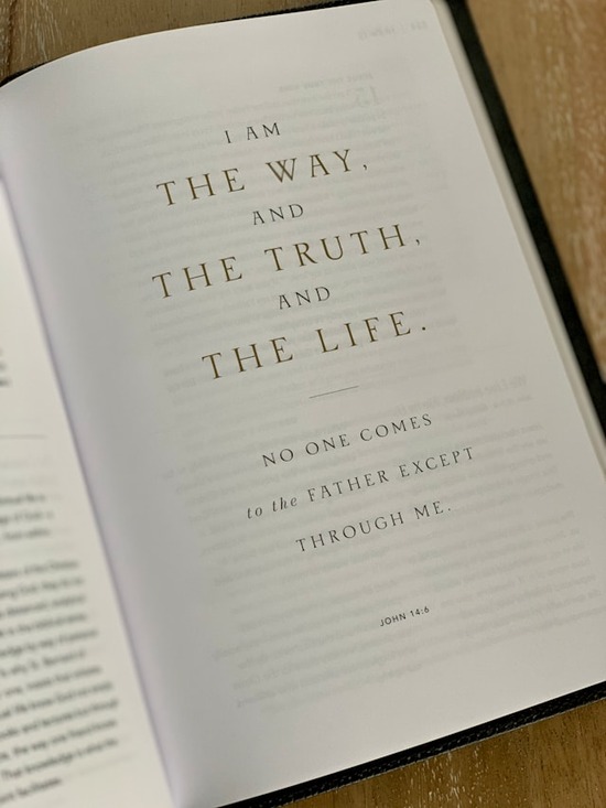 A page of the Bible reading, 'I am the way, and the truth, and the life. No one comes to the Father except through me.' (John 14:6).