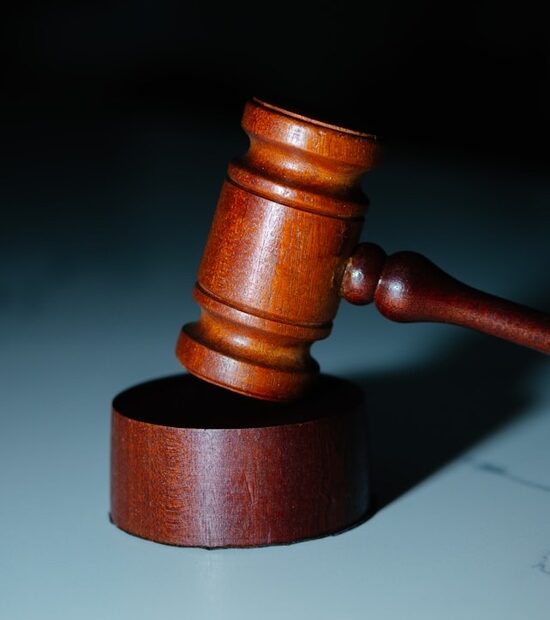 A wooden gavel hitting the top of a wooden block.