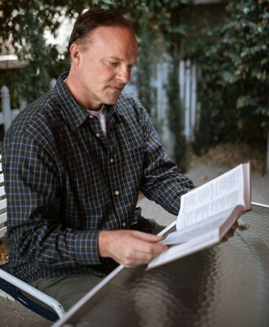  A man sitting in a chair and reading the Bible