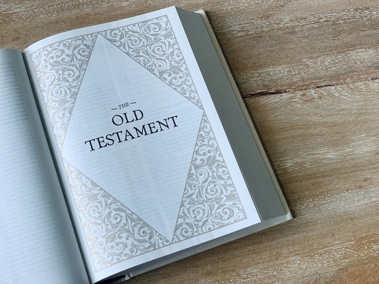 A Bible opened to the title page of the Old Testament.