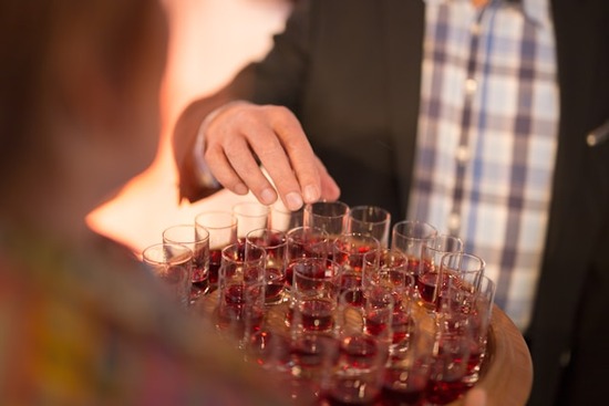 A person taking a cup of grape juice from a platter during a celebration of the Lord's Supper