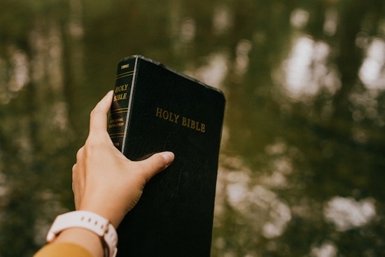 A person holding a Bible